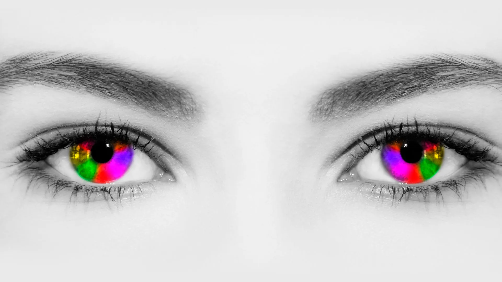 Zwei Augen mit regenbogenfarbener Iris in Schwarz-Weiß