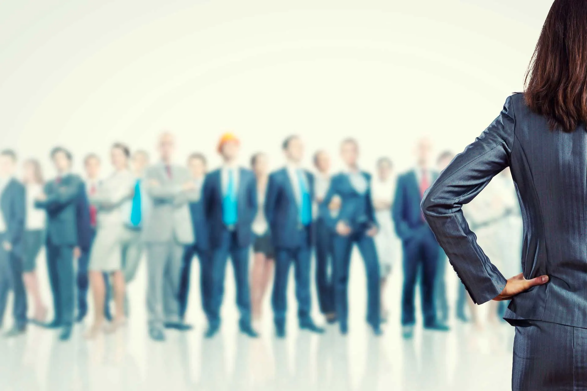 Eine Geschäftsfrau steht vor einer Gruppe von Menschen in Business-Kleidung